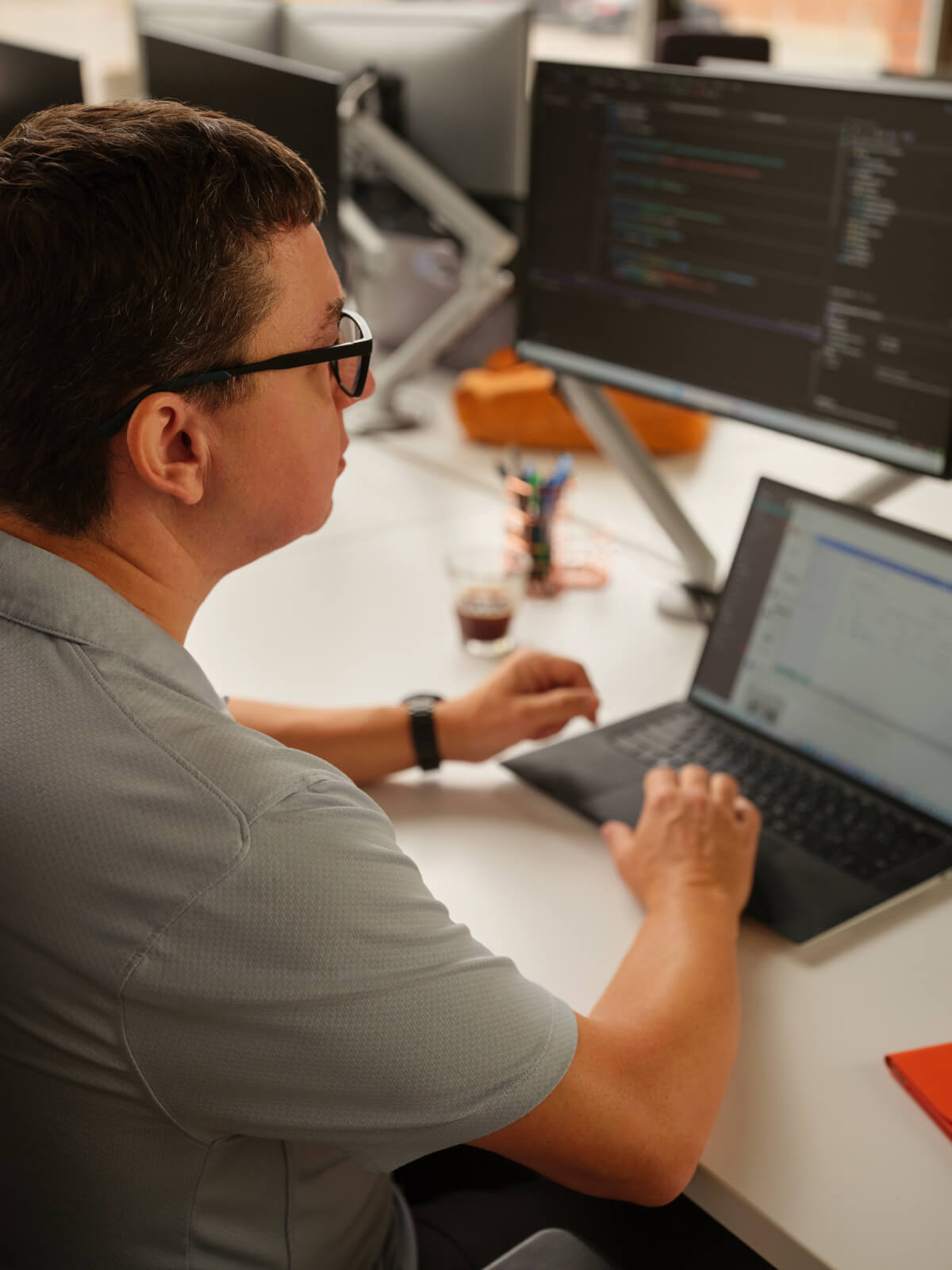 Developer writing code in Workleap's collaborative office space.